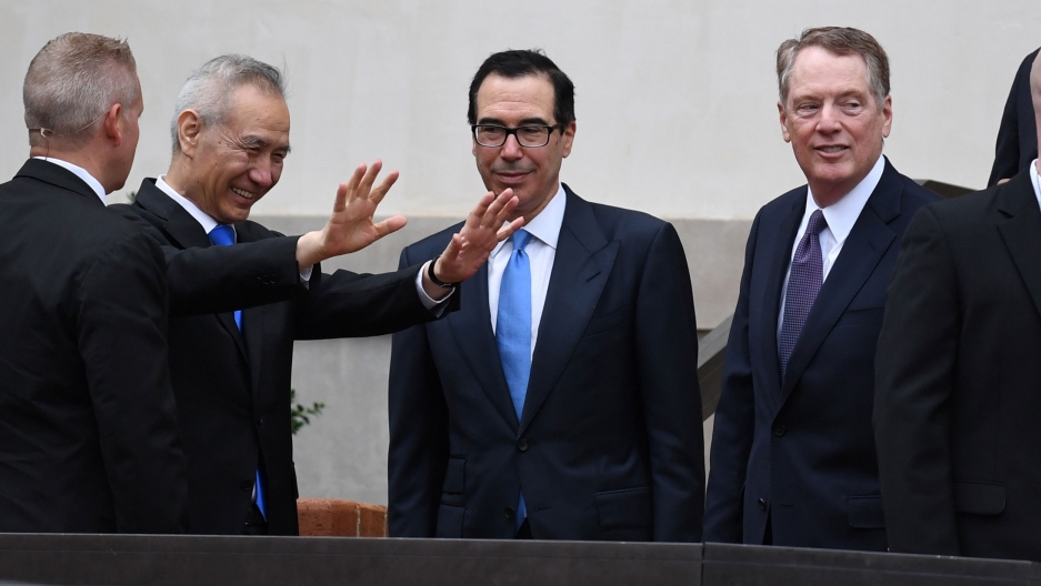 Chinese Vice Premier Liu He reacts as he talks with US Treasury Secretary Steven Mnuchin and Trade Representative Robert Lighthizer as he arrives to continue trade talks in Washington, DC, May 10, 2019. Chinese Vice Premier Liu He is shown with his hands outstretched and smiling next to Treasury Secretary Steven Mnuchin and Trade Representative Robert Lighthizer.