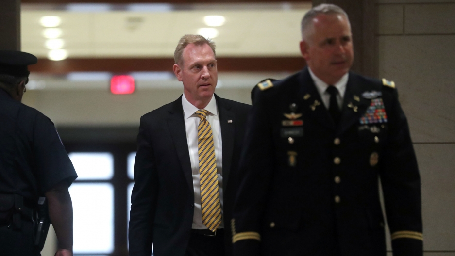 US Acting Defense Secretary Patrick Shanahan arrives to hold a classified briefing on Iran for members of the House of Representatives in Washington, DC, May 21, 2019. US Acting Defense Secretary Patrick Shanahan is shown walking in the background with a man in a US military uniform in the nearground.