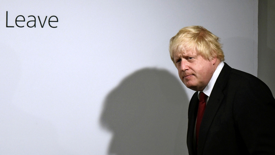 Boris Johnson arrives at the Leave campaign headquarters in London, Britain, 2016. Boris Johnson is shown walking in front of a white background with the word, "Leave" printed on it.