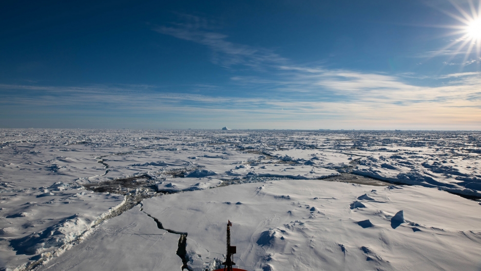 The Nathaniel B. Palmer breaking through ice floes during its southward transit. The front of the Nathaniel B. Palmer ship is shown at the bottom of the photo breaking through ice floes.