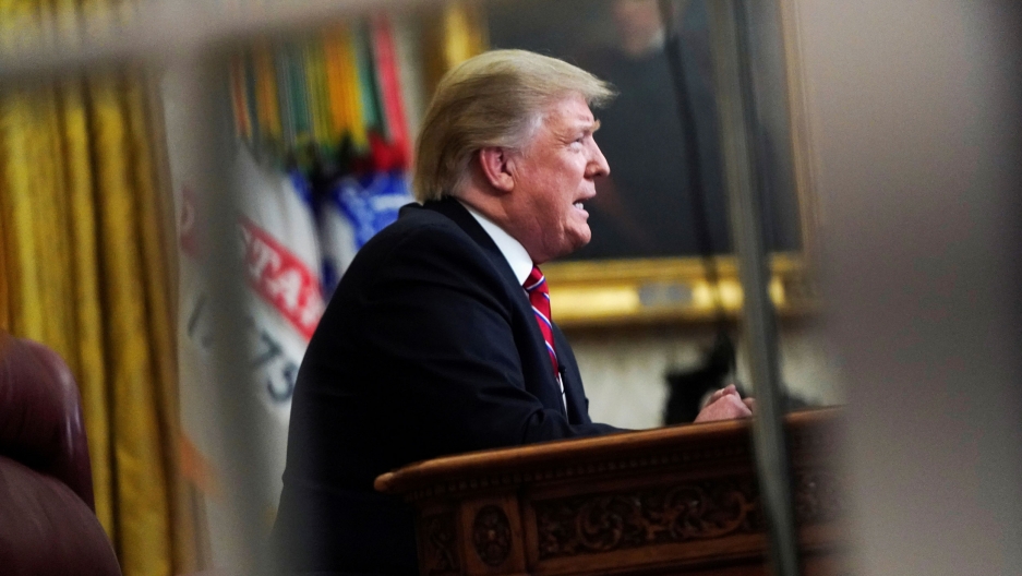 Ambassador Darroch described Trump's administration as "dysfunctional," "clumsy" and "inept" in a series of confidential memos, the British newspaper, the Mail on Sunday reported. A photograph of President Donal Trump is seen through a window pane showing him sitting at a desk.