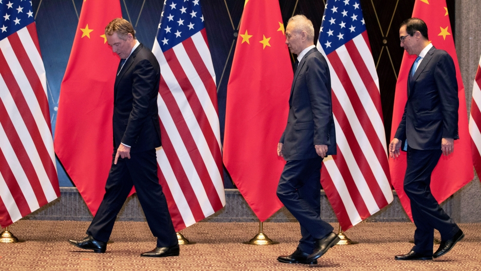 US Trade Representative Robert Lighthizer, Chinese Vice Premier Liu He and Treasury Secretary Steven Mnuchin are shown at the Xijiao Conference Center in Shanghai, China, July 31, 2019. US Trade Representative Robert Lighthizer, Chinese Vice Premier Liu He and Treasury Secretary Steven Mnuchin are shown wearing suits and walking past Chinese and US flags.