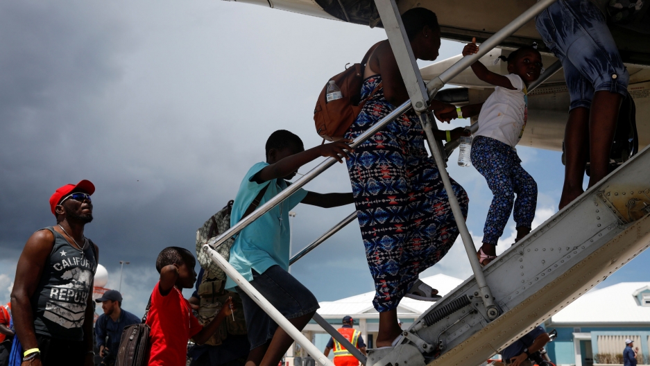 People walk up a ramp into an airplane