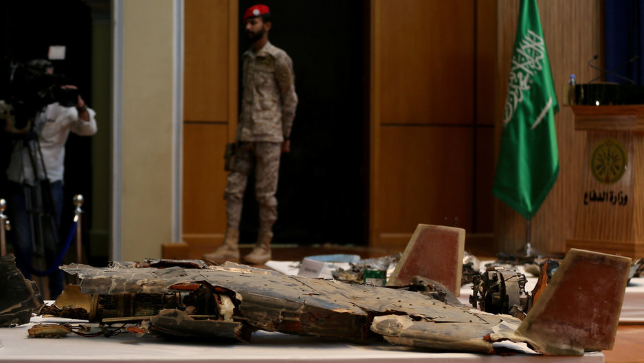 Remains of the missiles which Saudi government says were used to attack an Aramco oil facility, are displayed during a news conference in Riyadh, Saudi Arabia September 18, 2019. A pile of metal wreckage is shown on a table in the nearground with an armed security personel in the background.