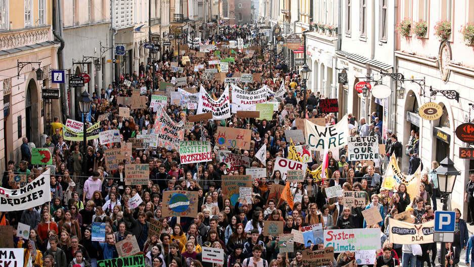 Activists take part in an environmental demonstration, part of the Global Climate Strike, in Krakow, Poland, Sept. 20, 2019. A street is shown filled with activist holding colorful signs.