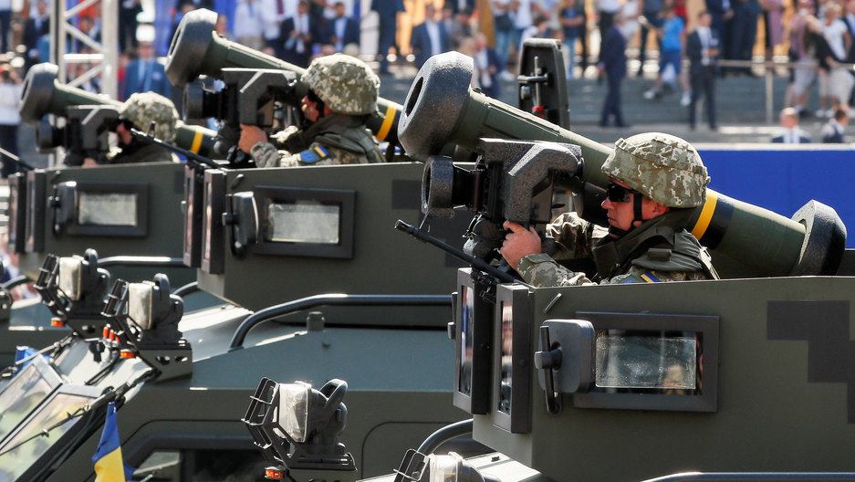 Ukrainian Army servicemembers ride with Javelin anti-tank missiles during a military parade in Kyiv, Ukraine, 2018. Ukrainian Army servicemembers are shown dressed in combat helmet and sunglasses while riding with Javelin anti-tank missiles.