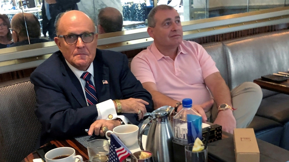 Two men sit at a table