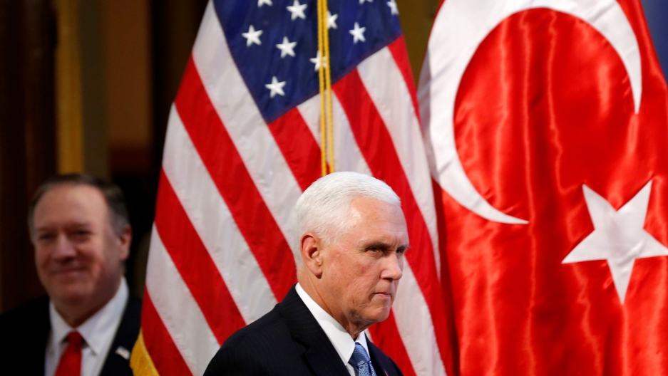 US Vice President Mike Pence and Secretary of State Mike Pompeo arrive to address a news conference at the US Embassy in Ankara, Turkey, Oct. 17, 2019. US Vice President Mike Pence is shown wearing a dark suit and blue tie and walking past the US and Turkey flags