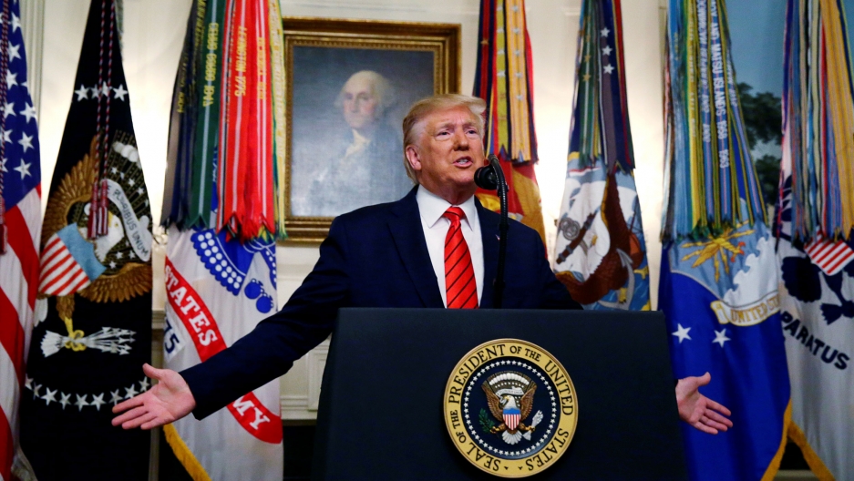President Donald Trump makes a statement at the White House following reports that US forces attacked ISIS leader Abu Bakr al-Baghdadi, Oct. 27, 2019. US President Donald Trump is shown standing at a podium with a seal for the US president with a painting of George Washington behind him.