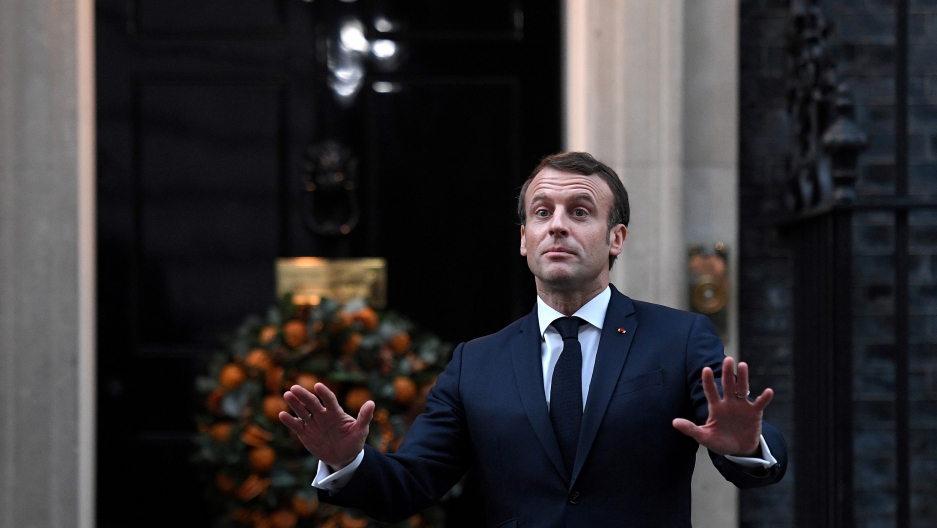 France's President Emmanuel Macron gestures as he arrives at 10 Downing Street ahead of the NATO summit in London, Britain, Dec. 3, 2019. France's President Emmanuel Macron is shown with both of his hands outstretched and wearing a blue suit.