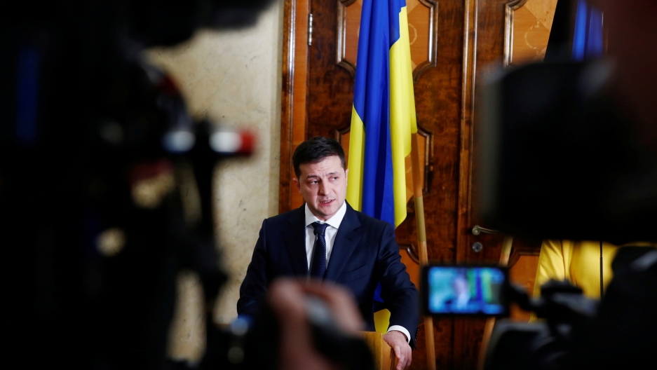 Ukraine's President Volodymyr Zelenskiy speaks during a news conference in Estonia, Nov. 26, 2019. Ukraine's President Volodymyr Zelenskiy is shown standing at a podium with microphones and several cameras in the nearground.
