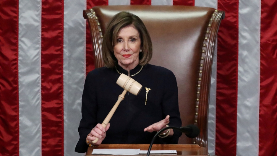 US Speaker of the House Nancy Pelosi wields the gavel as she presides over the House of Representatives approving two counts of impeachment against President Donald Trump in Washington DC, Dec. 18, 2019. US Speaker of the House Nancy Pelosi wields the gavel and stands in front of a large US flag.