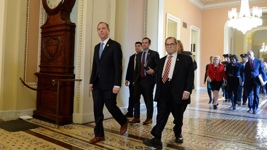 House Managers lead by Rep. Adam Schiff and Rep. Jerry Nadler walk to the Senate floor for the Senate impeachment trial of President Donald Trump in Washington, DC, Jan. 23, 2020. A group of lawmakers are shown wearing dark suits and walking on a marble floor.