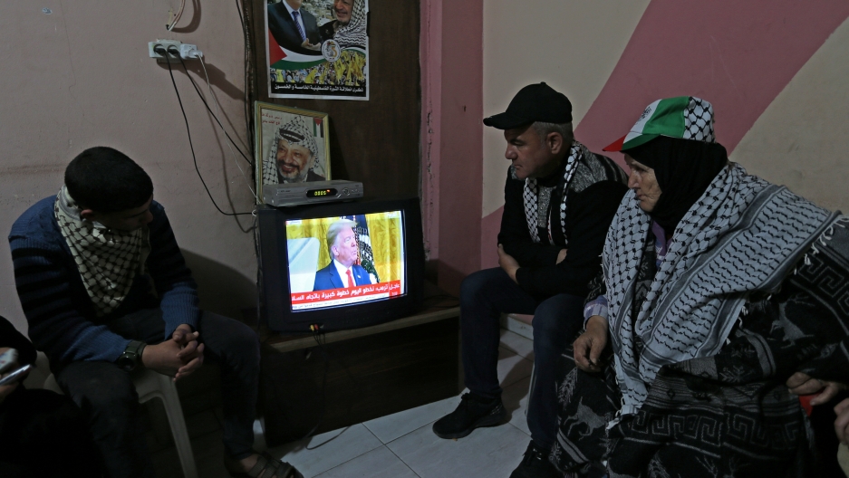 Palestinians watch a television broadcasting the announcement of Middle East peace plan by US President Donald Trump, in the southern Gaza Strip on Jan. 28, 2020.