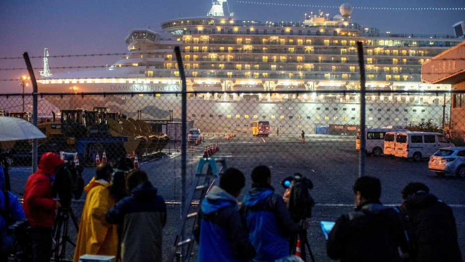 A bus arrives near the cruise ship Diamond Princess, where dozens of passengers were tested positive for coronavirus, at Daikoku Pier Cruise Terminal in Yokohama, south of Tokyo, Japan, on February 16, 2020. A bus arrives near the cruise ship Diamond Princess, where dozens of passengers were tested positive for coronavirus, at Daikoku Pier Cruise Terminal in Yokohama, south of Tokyo, Japan, on February 16, 2020.