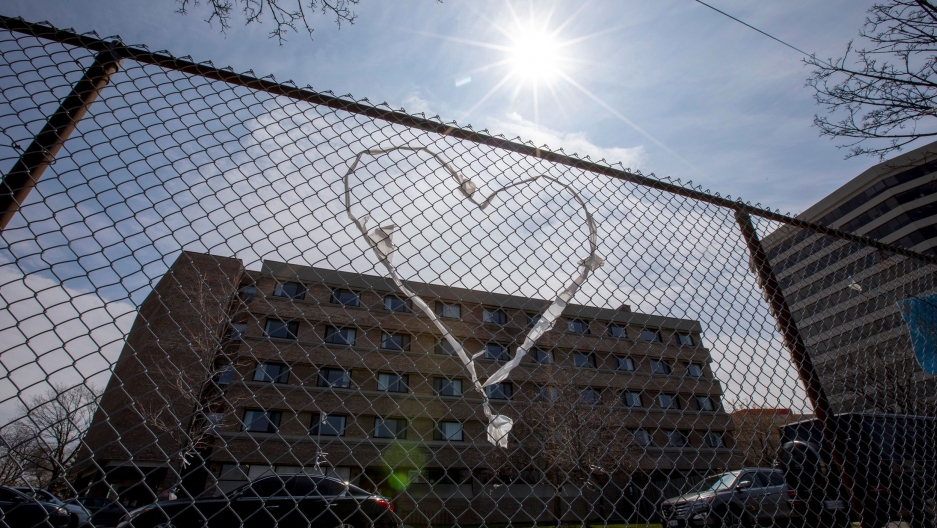 Signs of support for workers at Eatonville Care Center, a long term care home, after several residents died of the coronavirus in Toronto, Canada, April 23, 2020. A chain-link fence is shown with a clothe heart woven into it and a brick building in the background.
