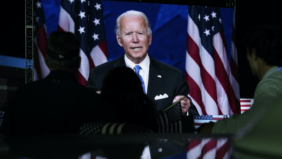 In this Aug. 20, 2020, file photo supporters watch the program outside the venue where Democratic presidential candidate former Vice President Joe Biden is speaking, during the Democratic National Convention at the Chase Center in Wilmington, Delaware.