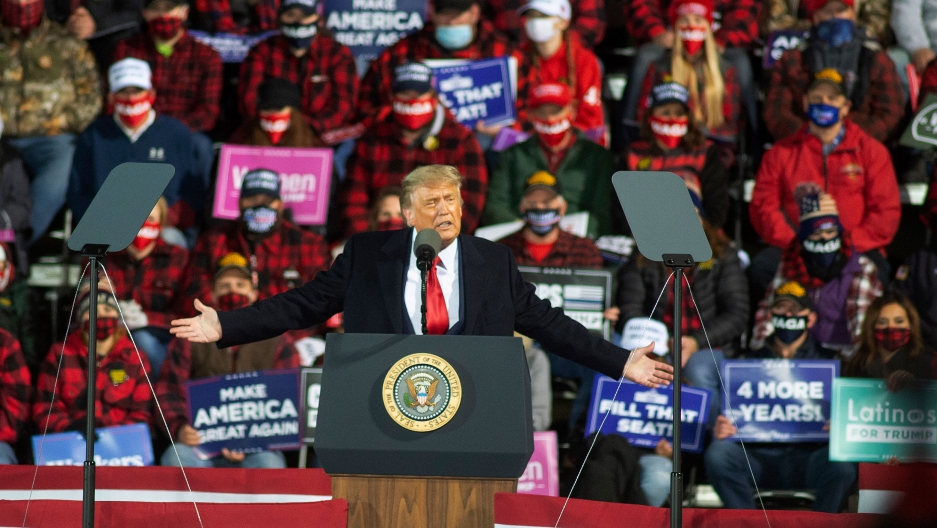 US President Donald Trump speaks during a rally in Duluth, Minn, Sept. 30, 2020. US President Donald Trump is shown with his arms outstretched, speaking at a podium with a crowd of people behind him.