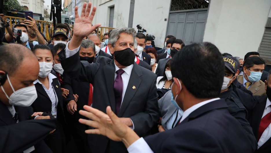 Peru's new President Francisco Sagasti waves to the crowd after he was designated by Congress to lead the nation, in Lima, Peru, Nov. 16, 2020. Peru's new President Francisco Sagasti is shown among a large crowd of people while wearing a face mask and waving.