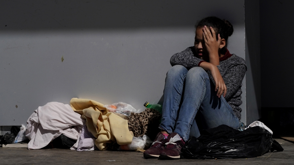 A migrant shields herself from the sun A migrant shields herself from the sun