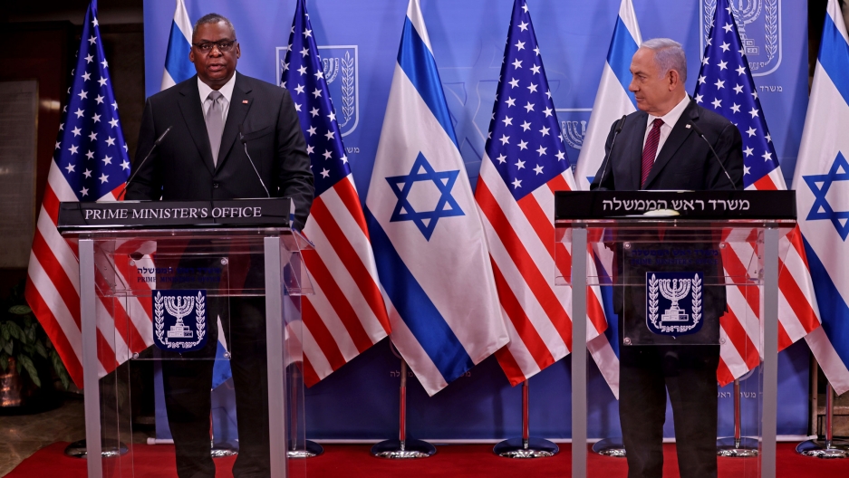 US Defense Secretary Lloyd Austin (L) and Israeli Prime Minister Benjamin Netanyahu give statements after their meeting, at the prime minister's office, in Jerusalem, April 12, 2021. US Defense Secretary Lloyd Austin and Israeli Prime Minister Benjamin Netanyahu are shown each standing behind podiums with US and Israeli flags in the background.