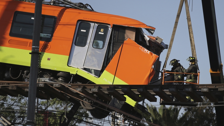 Firefighters work to lower to the ground a subway car dangling from a collapsed elevated section of the metro, in Mexico City, Tuesday, May 4, 2021. Firefighters work to lower to the ground a subway car dangling from a collapsed elevated section of the metro, in Mexico City, Tuesday, May 4, 2021.