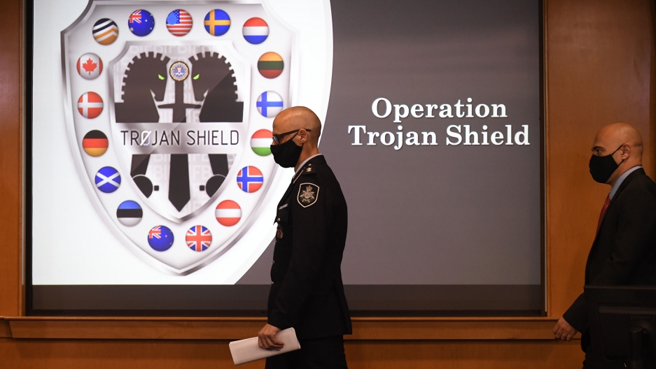 Law enforcement officials walk past an Operation Trojan Shield logo at a news conference, Tuesday, June 8, 2021, in San Diego. Law enforcement officials walk past an Operation Trojan Shield logo at a news conference, Tuesday, June 8, 2021, in San Diego.