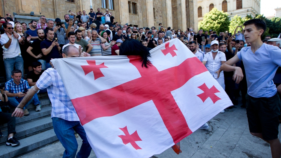 Opponents of the march wave a Georgian national flag as they block off the capital's main avenue to an LGBTQ march in Tbilisi, Georgia, Monday, July 5, 2021. Opponents of the march wave a Georgian national flag as they block off the capital's main avenue to an LGBTQ march in Tbilisi, Georgia, Monday, July 5, 2021.