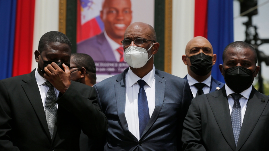 Haiti's designated Prime Minister Ariel Henry, center, and interim Prime Minister Claude Joseph, right, pose for a group photo with other authorities in front of a portrait of late Haitian President Jovenel Moïse at at the National Pantheon Museum during Haiti's designated Prime Minister Ariel Henry, center, and interim Prime Minister Claude Joseph, right, pose for a group photo with other authorities in front of a portrait of late Haitian President Jovenel Moïse at at the National Pantheon Museum during