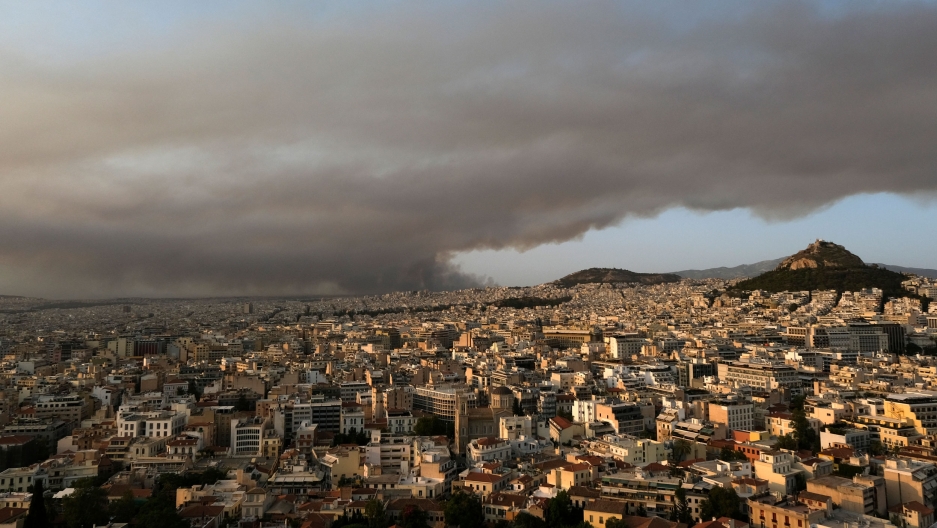 Smoke from a wildfire north of the Greek capital, spreads over Athens, Greece, Aug. 3, 2021. A view of Athens from above showning the city and in the distance large dark smoke clouds filling the sky.