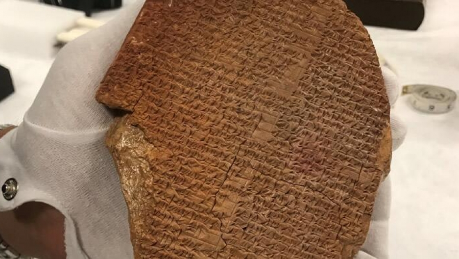 The Gilgamesh Dream Tablet seized by US authorities. White-gloved hand holds ancient artifact known as the Gilgamesh Dream Tablet.