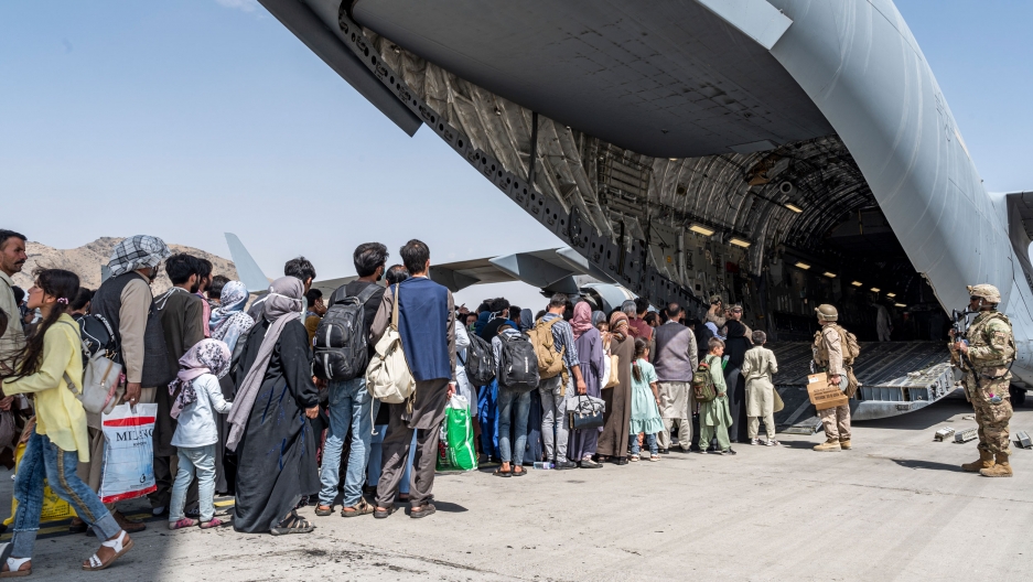 In this Aug. 21, 2021, image provided by the U.S. Air Force, US Airmen and U.S. Marines guide evacuees aboard a U.S. Air Force C-17 Globemaster III in support of the Afghanistan evacuation at Hamid Karzai International Airport in Kabul, Afghanistan. In this Aug. 21, 2021, image provided by the U.S. Air Force, US Airmen and U.S. Marines guide evacuees aboard a U.S. Air Force C-17 Globemaster III in support of the Afghanistan evacuation at Hamid Karzai International Airport in Kabul, Afghanistan.