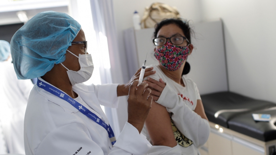 A resident gets a dose of the AstraZeneca vaccine on the first day of a three-day COVID-19 vaccination campaign for people over age 35 in the Complexo da Maré favela of Rio de Janeiro, Brazil, Brazil, Thursday, July 29, 2021. A resident gets a dose of the AstraZeneca vaccine on the first day of a three-day COVID-19 vaccination campaign for people over age 35 in the Complexo da Maré favela of Rio de Janeiro, Brazil, Brazil, Thursday, July 29, 2021.