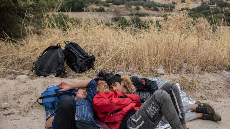 In this Monday, Oct. 7, 2019 photo, exhausted Afghan youths sleep on the ground near the town of Madamados after their arrival with other migrants and refugees on a rubber boat from Turkey, at Lesbos Island, Greece. In this Monday, Oct. 7, 2019 photo, exhausted Afghan youths sleep on the ground near the town of Madamados after their arrival with other migrants and refugees on a rubber boat from Turkey, at Lesbos Island, Greece.