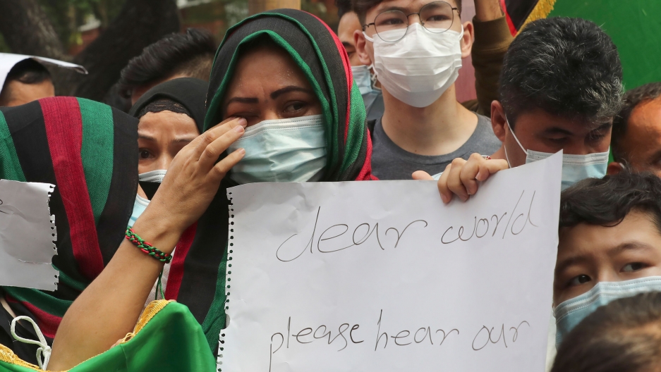 An Afghan woman weeps as she holds a poster during a rally outside the building that houses UNHCR representative office in Jakarta, Indonesia, Tuesday, Aug. 24, 2021. An Afghan woman weeps as she holds a poster during a rally outside the building that houses UNHCR representative office in Jakarta, Indonesia, Tuesday, Aug. 24, 2021.