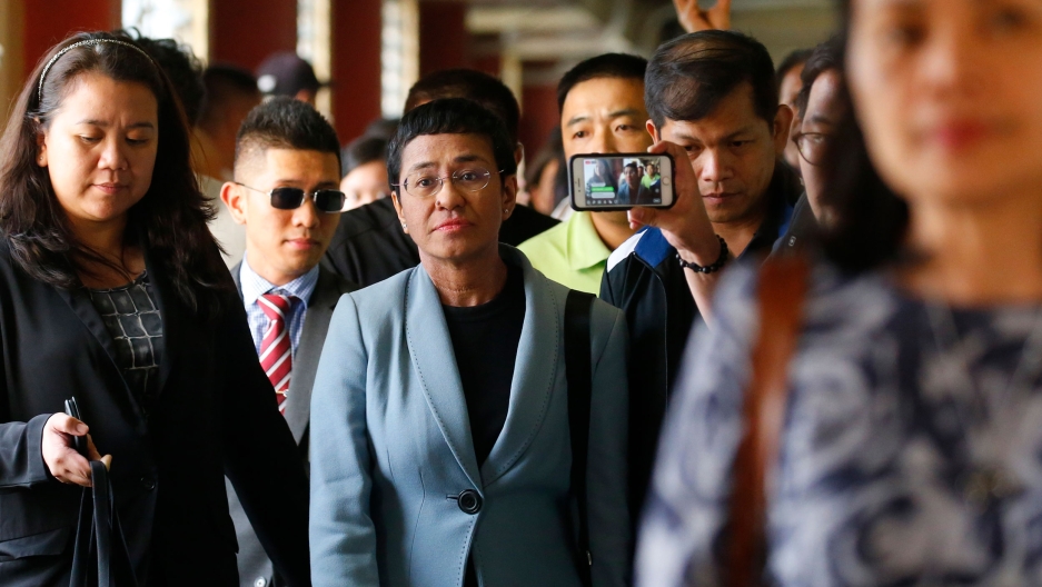 Maria Ressa, center, the award-winning head of a Philippine online news site Rappler, is escorted into the court room to post bail at a Regional Trial Court following an overnight arrest by National Bureau of Investigation agents on a libel case Thursday, Maria Ressa, center, the award-winning head of a Philippine online news site Rappler, is escorted into the court room to post bail at a Regional Trial Court following an overnight arrest by National Bureau of Investigation agents on a libel case Thursday,
