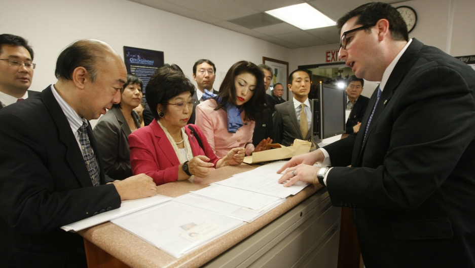 Tokyo councilwoman Yoshiko Matsuura presents Glendale, California, city clerk Ardashes Kassakhian with a letter demanding the city remove its memorial to World War Two-era “comfort women.”