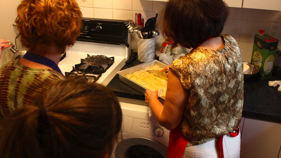 Despina cuts the Tiropita before putting it in the oven to bake. Despina cuts the Tiropita before putting it in the oven to bake.