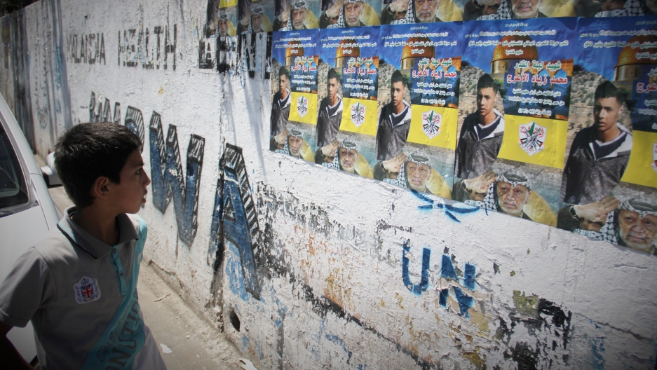 A boy in the Qalandiya refugee camp looks at a martyr poster of Mohammed Al-Araj, who was killed in clashes with the Israeli army. A boy in the Qalandiya refugee camp looks at a martyr poster of Mohammed Al-Araj, who was killed in clashes with the Israeli army.