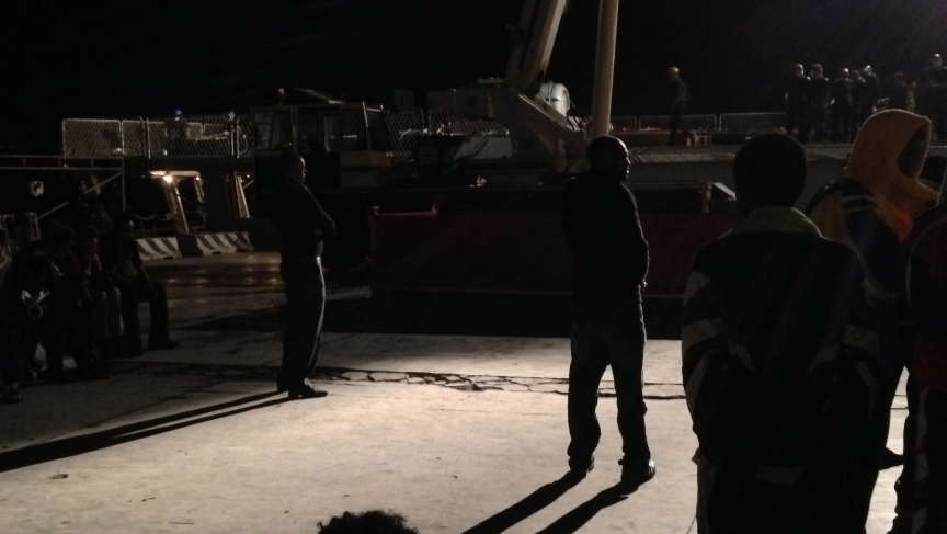 Families in the port watch coffins transport: Hundreds of people stood on Lampedusa's port on the night of October 13 to bid farewell to their loved ones as a crane transfers the coffins into a navy boat for an uncertain funeral in Sicily. Families in the port watch coffins transport: Hundreds of people stood on Lampedusa's port on the night of October 13 to bid farewell to their loved ones as a crane transfers the coffins into a navy boat for an uncertain funeral in Sicily.