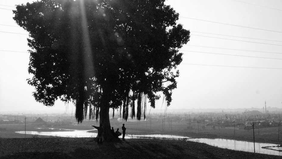 Immigrants from Nepal sit overlooking the Ganges River. Nepal has an open border with India. Immigrants from Nepal sit overlooking the Ganges River. Nepal has an open border with India.