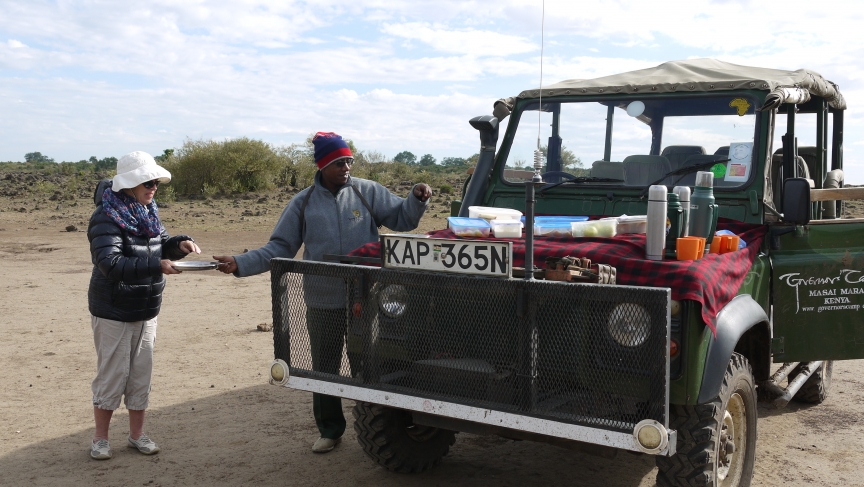 John Karanjah helps a guest with a picnic breakfast