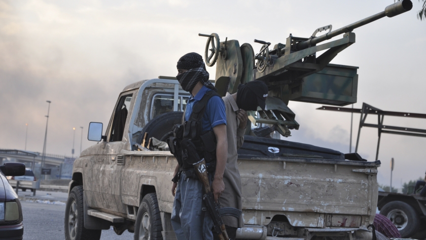 ISIS fighters stand guard at a checkpoint in the northern Iraq city of Mosul, June 11, 2014. 