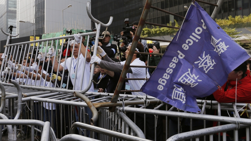Pro-democracy protesters dismantle a barricade, in accordance with a court injunction to clear part of the protest site. The demonstrators set up camp at the end of September 2014. 