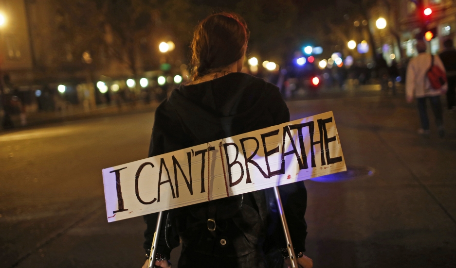 A protester in Oakland, California, on  December 3, 2014, wears a sign during a demonstration against the decision by a New York City grand jury not to indict a police officer in the death of Eric Garner.