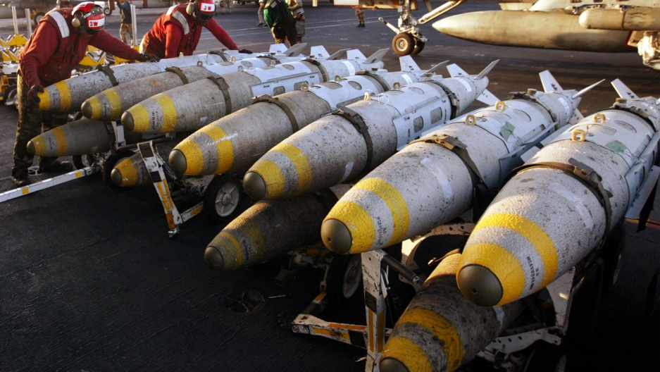Aviation ordinancemen organize 1000 pound MK-83 JDAM (Joint Direct Attack Munition) bombs on their racks on the flight deck of the USS Kitty Hawk aircraft carrier in this archival photo taken in the northern Persian Gulf March 18, 2003. 