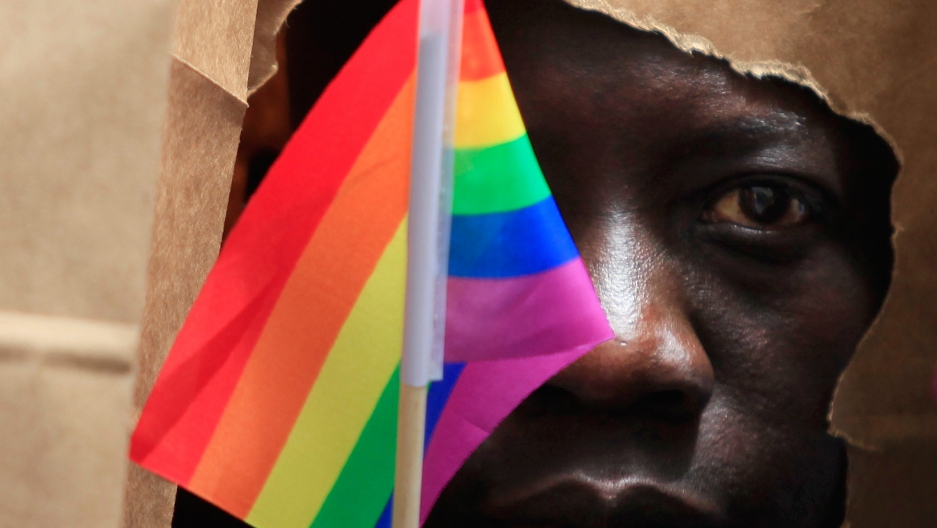 An asylum-seeker from Uganda covers his face with a paper bag in order to protect his identity as he marches with the LGBT Asylum Support Task Force during the Gay Pride Parade in Boston, Massachusetts, June 8, 2013. 
