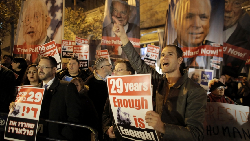 Israelis hold placards during a protest calling for the release of Jonathan Pollard from U.S. prison, outside U.S. Secretary of State John Kerry's hotel in Jerusalem on January 2, 2014. 