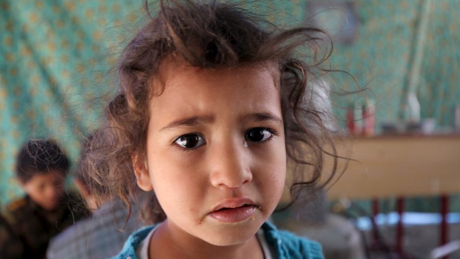 An internally displaced girl waits for her turn to receive food at a school in Sanaa May 17, 2015. Residents were forced to leave their homes in the nearby province of Saada amidst Saudi-led air strikes.
