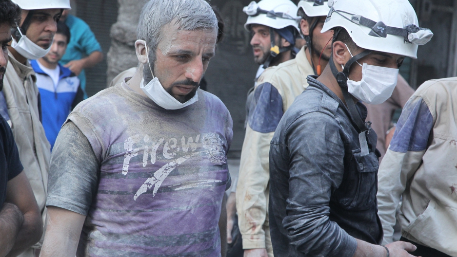 White Helmet volunteers search for survivors at a site reportedly hit with a barrel bomb in the Al-Shaar neighborhood of Aleppo, Syria, on September 17, 2015.